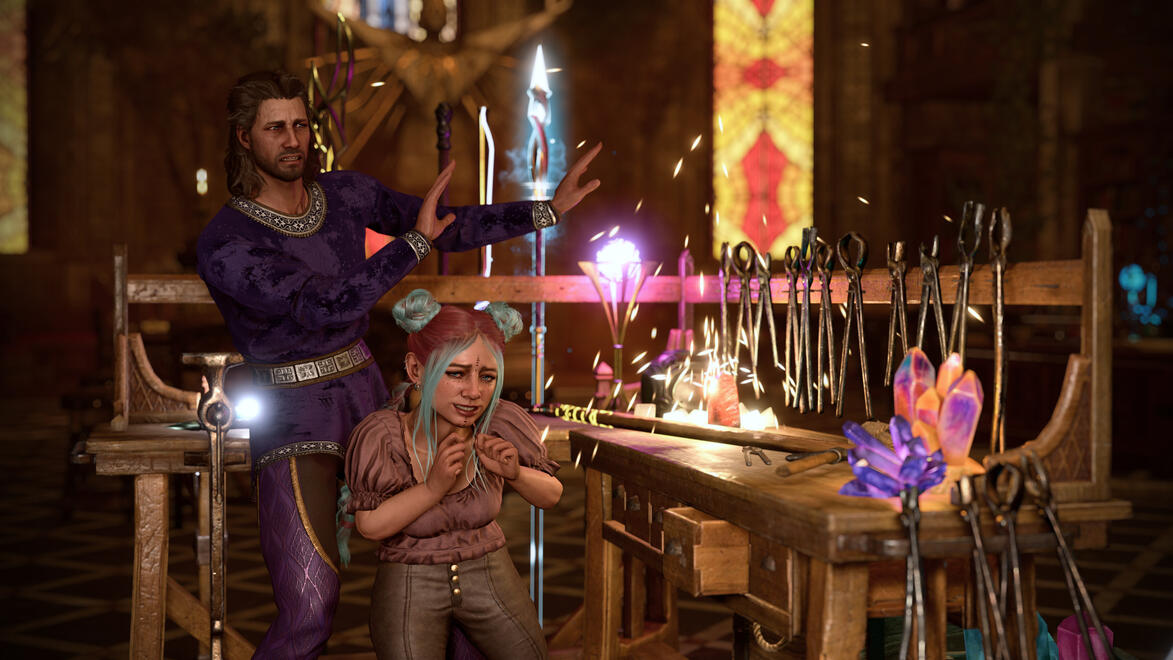 Gale and Ravioli are standing next to a work table with a staff and other magical equipment on it. The staff is sparking. Ravioli is wincing and has an embarrassed expression. Gale has his hands up to block the sparks and has a startled expression. Clearly